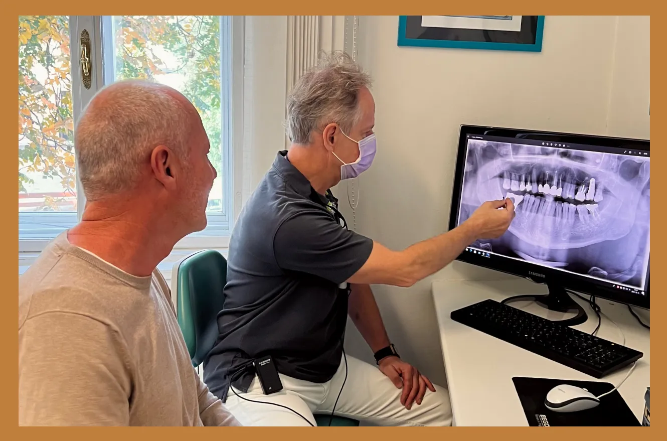 Dentist reviewing a digital X-ray with a patient during consultation at Harajda Dent