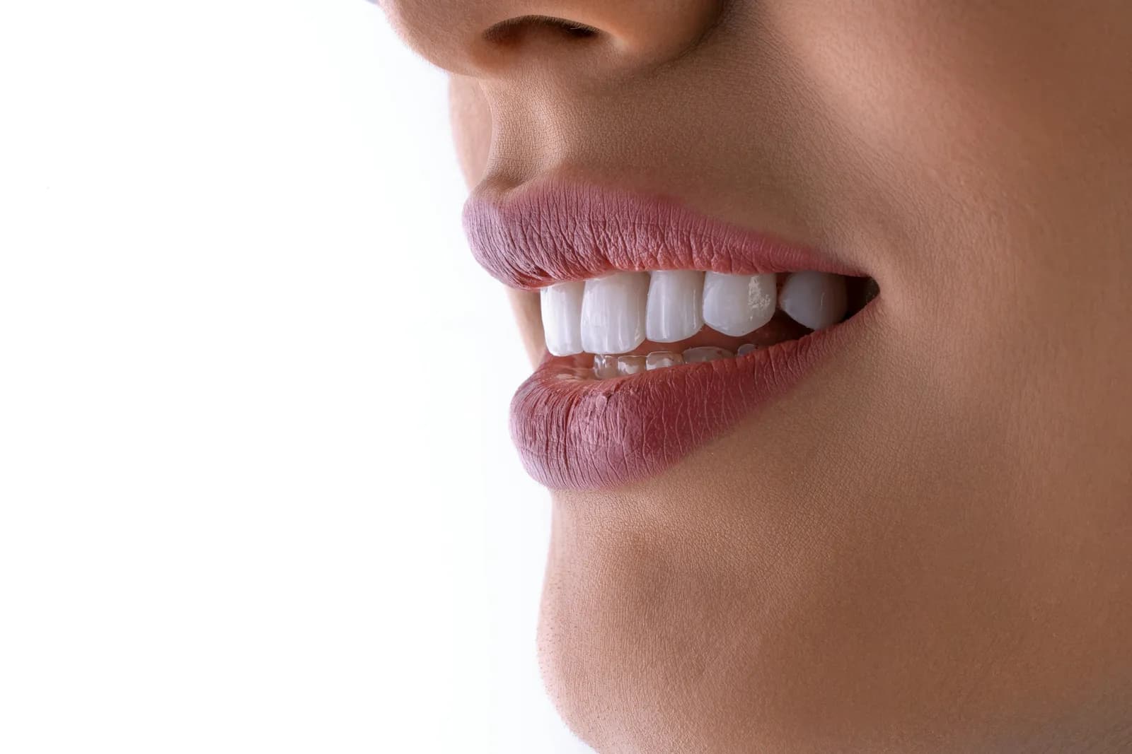 Illustrative macro side-profile close-up of a mouth showing white, evenly aligned teeth